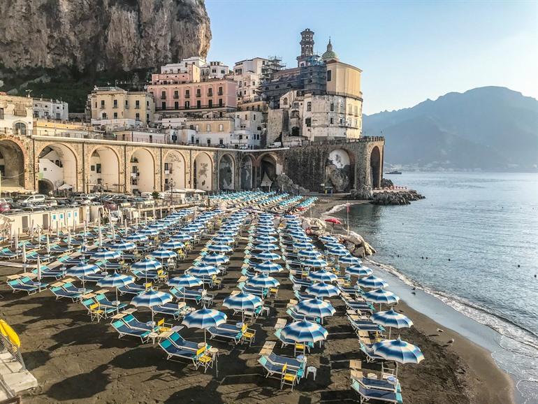 Blauwe parasols op het strand van Atrani