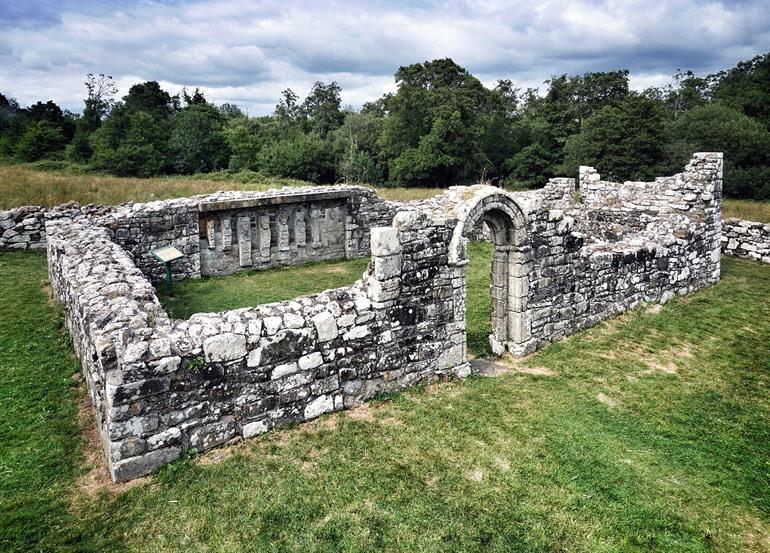 Ruïnes van een oude kerk met uit steen gehouwen figuren, White Island, Noord-Ierland